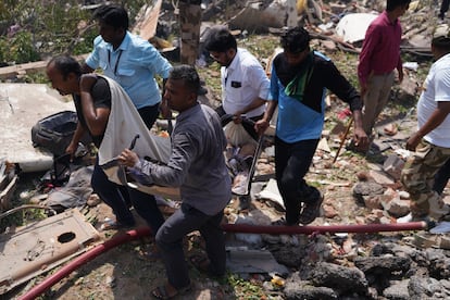 Los equipos de rescate extraen el cadáver de uno de los pasajeros del avión de Air India.