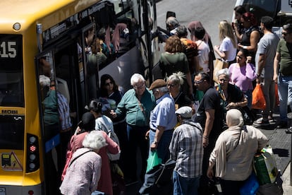 Un grupo de personas en una parada de autobús del barrio de Fondo de Santa Coloma de Gramenet (Barcelona).