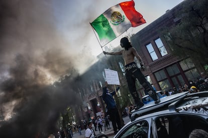 Un manifestante ondea una bandera de México subido a un coche de la Policía en Los Ángeles, el 8 de junio.