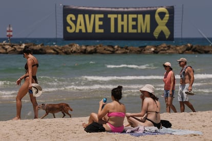 Una pancarta, en referencia a los rehenes retenidos por Hamás en la Franja de Gaza, se exhibía en la playa de Tel Aviv mientras la gente tomaba el sol el pasado viernes.
