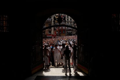 Vista, desde el interior del Ayuntamiento, de la salida a la plaza Consistorial de Pamplona de la banda municipal La Pamplonesa y los Txistularis municipales después del tradicional chupinazo.