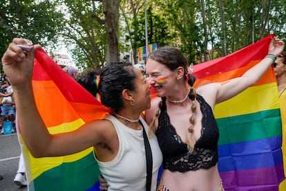Una pareja sujeta una bandera arcoíris durante la manifestación del Orgullo en Madrid, este sábado.